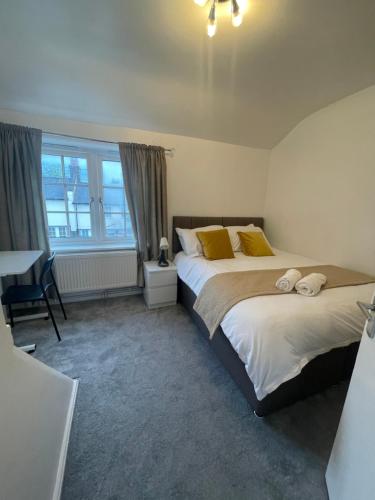 a bedroom with two beds with yellow pillows at Tooting Lodge London - Cosy 2 bedroom house with garden in London