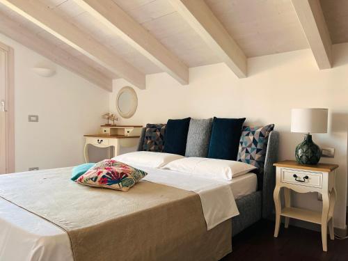 a bedroom with a bed and a table with a lamp at Casa di Alex | Sirmione in Sirmione