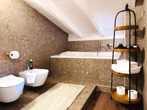 a bathroom with a sink and a toilet and a tub at Casa di Alex | Sirmione in Sirmione