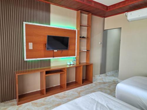 pokój hotelowy z telewizorem i łóżkiem w obiekcie Jelita Beach Mentawai w mieście Tua Pejat