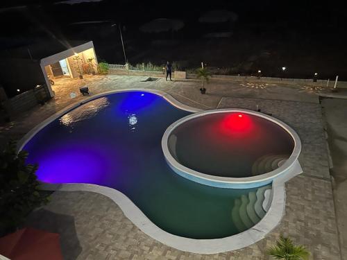 a swimming pool at night with a red light in it at Yobcar66 in San Fernando de Monte Cristi