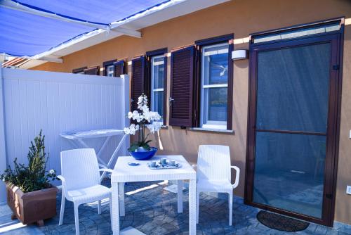 a patio with a white table and chairs and a window at La Laura di Paestum - case vacanze in Capaccio-Paestum