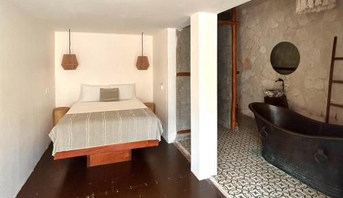 a bedroom with a bed and a bath tub at Alquimia Hotel Boutique in Tulum