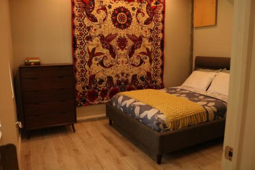 um quarto com uma cama e uma tapeçaria na parede em Charming Garden Apartment em University Place