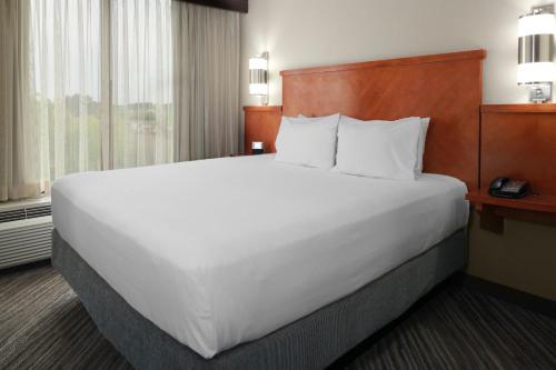 a large white bed in a hotel room at Candlewood Suites - Cincinnati Northeast - Mason by IHG in Mason