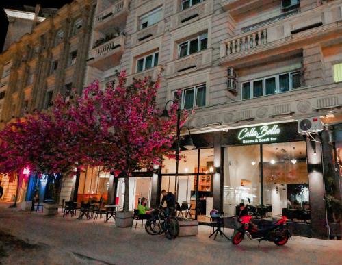 a store on a city street with trees in front of a building at Calla Bella Rooms & Snack Bar in Skopje