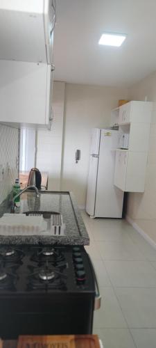 uma cozinha com um fogão e um frigorífico branco em Apartamento Torres Center em Torres