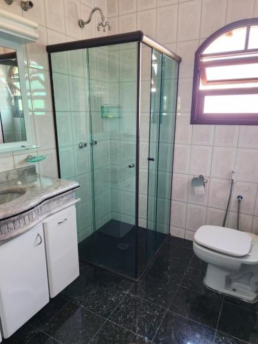 a bathroom with a glass shower and a toilet at Casa com 4 suítes com closet in Jarinu
