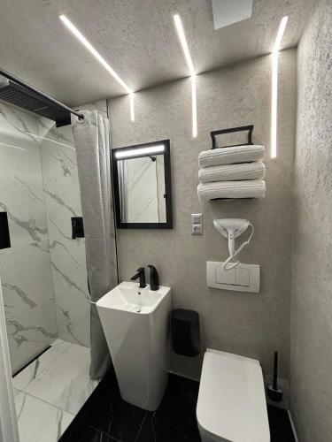 a white bathroom with a sink and a toilet at Apartament Miami in Ełk