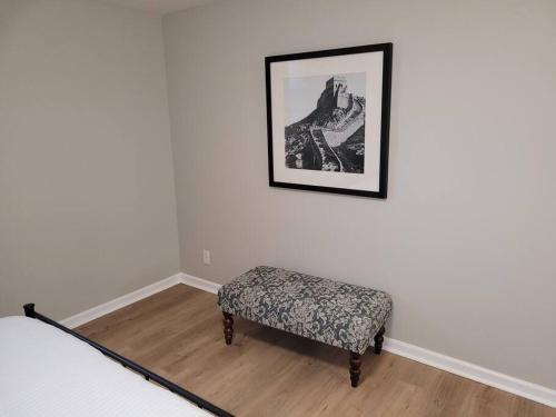 a bedroom with a bench and a picture on the wall at Davenport Dwellings-Three Bedroom in Omaha