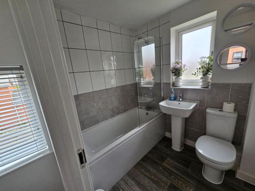 ein Badezimmer mit einer Badewanne, einem WC und einem Waschbecken in der Unterkunft Modern 3 Bedroom Town House in Ipswich in Ipswich
