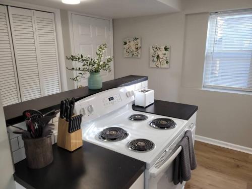 uma cozinha com um fogão branco e uma bancada preta em Davenport Dwellings Midtown Convenience em Omaha