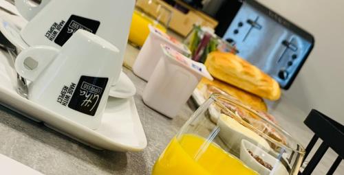 Una encimera de cocina con un exprimidor y una taza de jugo de naranja. en The Grey House, en Lunay