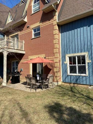 a patio with chairs and a table with an umbrella at Cosy Chalet - 4 Season Family Oasis in Collingwood