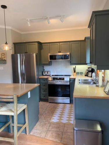 a kitchen with stainless steel appliances and a table at Cosy Chalet - 4 Season Family Oasis in Collingwood