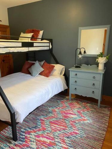 a bedroom with two beds and a dresser and a mirror at Cosy Chalet - 4 Season Family Oasis in Collingwood