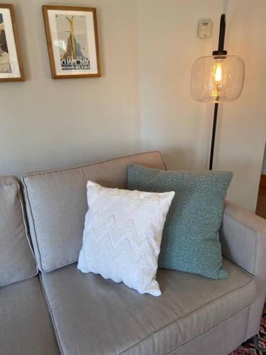 a couch with a pillow and a lamp in a living room at Cosy Chalet - 4 Season Family Oasis in Collingwood