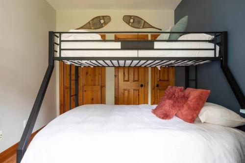 a bedroom with a bunk bed with white sheets and red pillows at Cosy Chalet - 4 Season Family Oasis in Collingwood