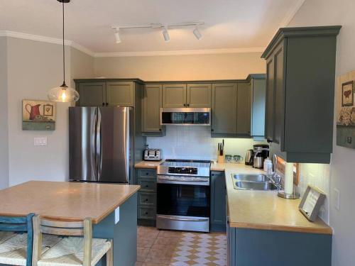 a kitchen with stainless steel appliances and a table at Cosy Chalet - 4 Season Family Oasis in Collingwood