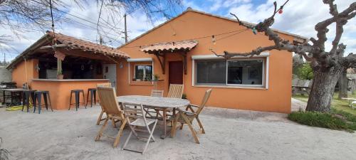 une table et des chaises devant une maison dans l'établissement Maison en Provence (Piscine / Grand jardin), à Beaucaire