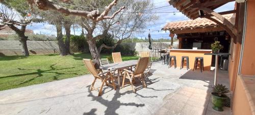 une table et des chaises en bois sur une terrasse dans l'établissement Maison en Provence (Piscine / Grand jardin), à Beaucaire