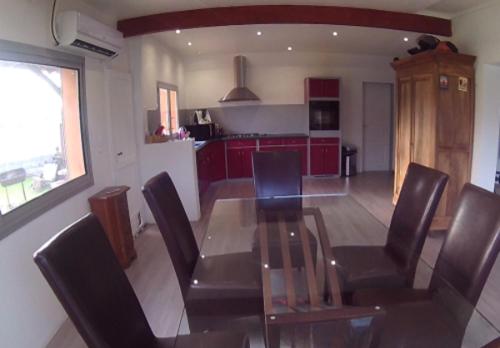 une salle à manger avec une table et des chaises en verre dans l'établissement Maison en Provence (Piscine / Grand jardin), à Beaucaire