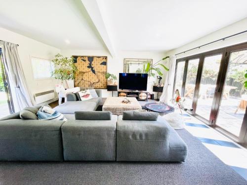 a living room with a couch and a tv at Stunning cottage in Christchurch