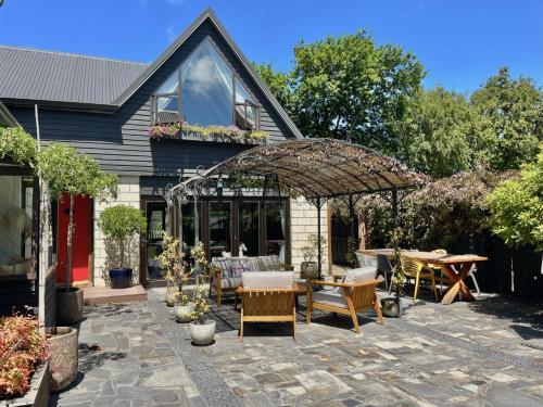 an outdoor patio with a table and chairs at Stunning cottage in Christchurch