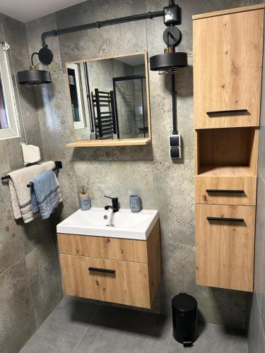 a bathroom with a sink and a mirror at Apartament przy plaży Marlina in Niewiesze