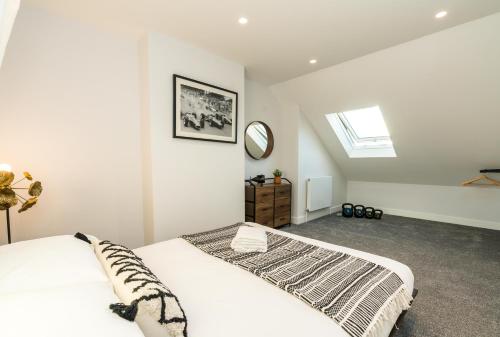 a white bedroom with a bed and a mirror at WestKensington-BaronsCourt-StylishDuplex-2bedrooms2Bath-Luxury in London