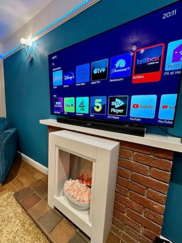 a living room with a tv and a fireplace at Accessible home in Sherwood in Nottingham