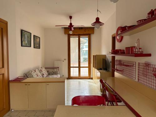 - un salon avec une table et des chaises rouges dans l'établissement Igea vacanza, à Bellaria-Igea Marina