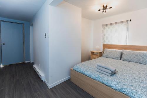 1 dormitorio con 1 cama con edredón azul en Avenir Centre Suite en Moncton