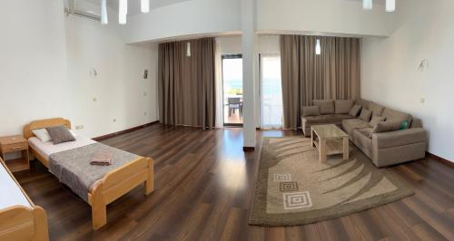 een woonkamer met een bed en een bank bij Regatta Inn in Ulcinj