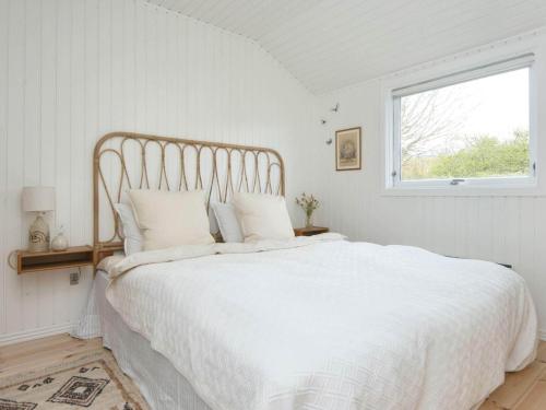 a white bed in a white bedroom with a window at Holiday home Struer XI in Struer