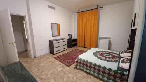 una camera con letto, cassettiera e specchio di la casa della nonna 39 a Noicattaro
