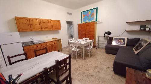 un soggiorno con divano e tavolo e una cucina di la casa della nonna 39 a Noicattaro