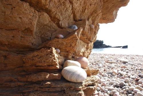 a stone wall on a beach with rocks at Bruadarach 'Visionary, Dreamer' in Dunbeath
