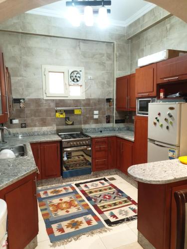 a kitchen with wooden cabinets and a kitchen rug on the floor at Magic Vella in Al Aqālitah