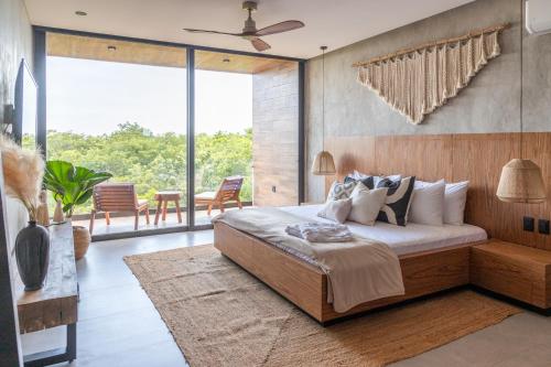 a bedroom with a large bed and a large window at Xambé in Tulum