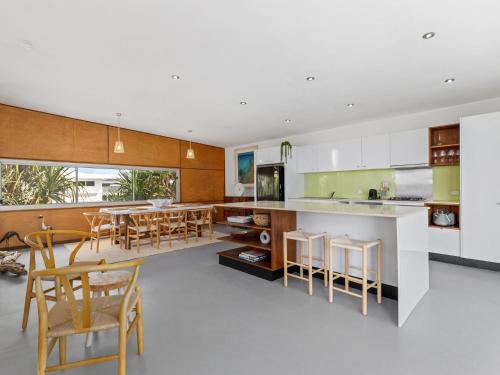 an open kitchen and dining room with a table and chairs at Ayana Casuarina in Casuarina