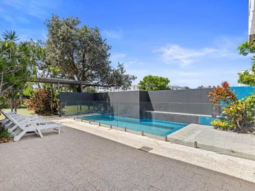 a swimming pool with a bench in front of a building at Ayana Casuarina in Casuarina