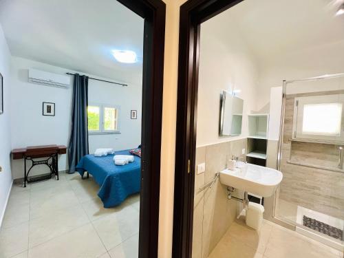 a bathroom with a bed and a sink and a mirror at L'Angolo del Saraceno in Carini