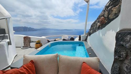 a hot tub on a deck with a view of the ocean at Aqua & Terra Traditional Cave Houses in Oia
