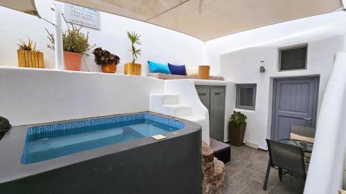 a swimming pool in the middle of a room at Aqua & Terra Traditional Cave Houses in Oia