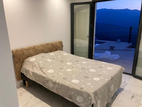 een bed in een kamer met een groot raam bij Villa Padula in Olmeta-di-Tuda