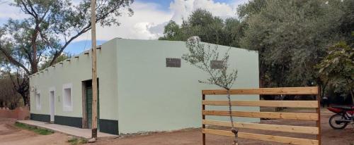 een klein wit gebouw met een houten hek bij CASA DE CAMPO SAN JOSE in Tinogasta