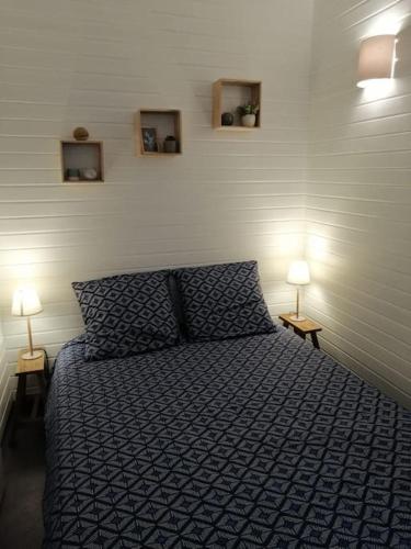 - une chambre avec un lit et deux lampes sur deux tables dans l'établissement Beau studio avec chambre séparée à 100m de la Gare, à Rouen