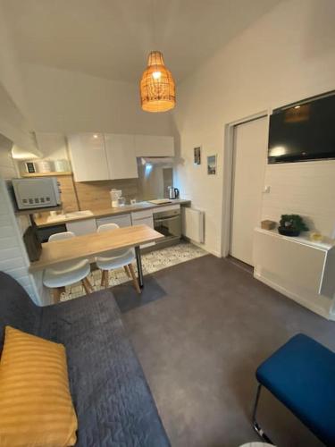 un salon avec une table et une cuisine dans l'établissement Beau studio avec chambre séparée à 100m de la Gare, à Rouen