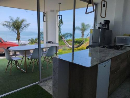 a kitchen with a counter and a table with chairs at Hermosa propiedad con vista al mar in Jama